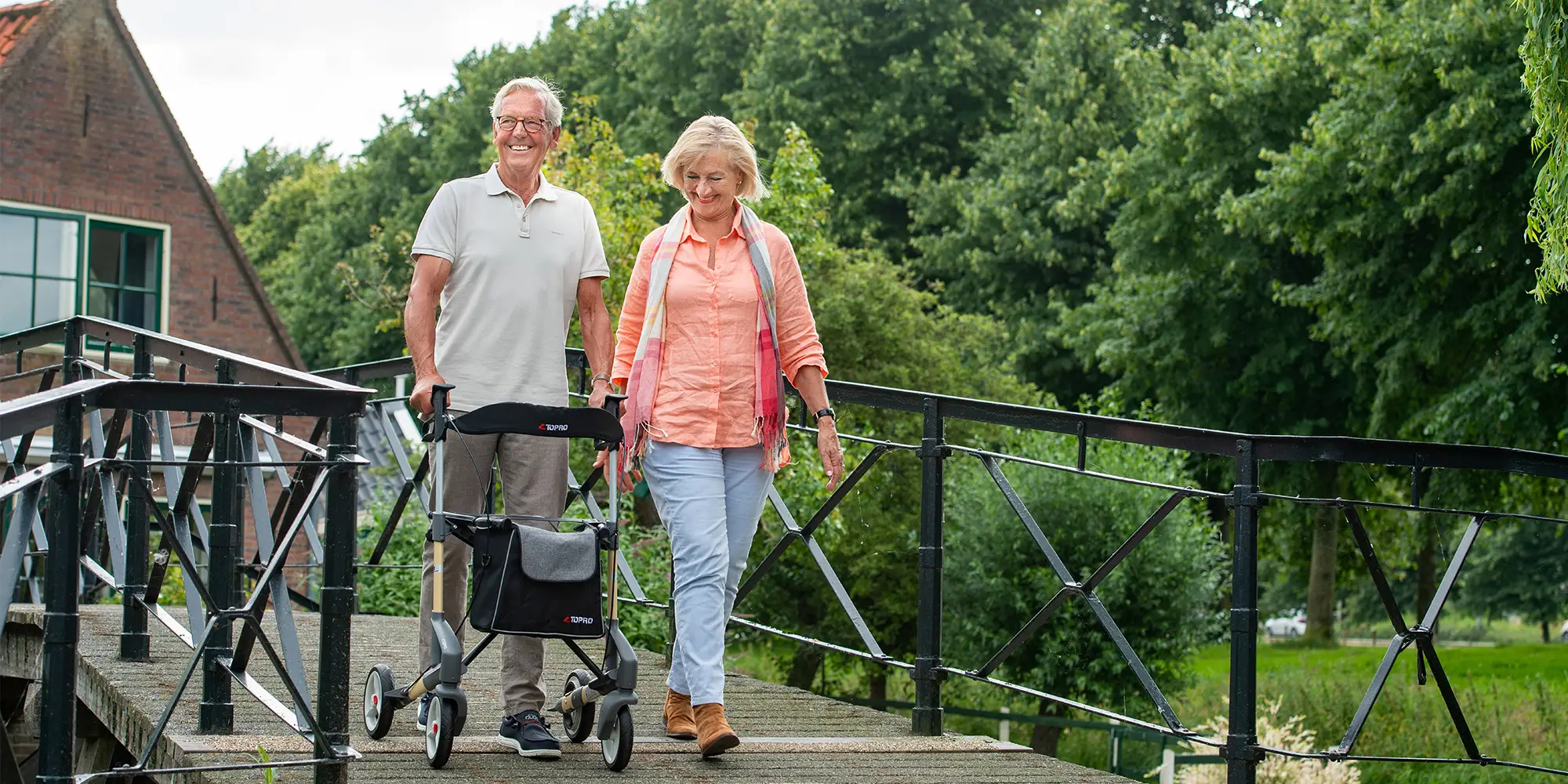 Twee ouderen wandelen gezond met rollator.
